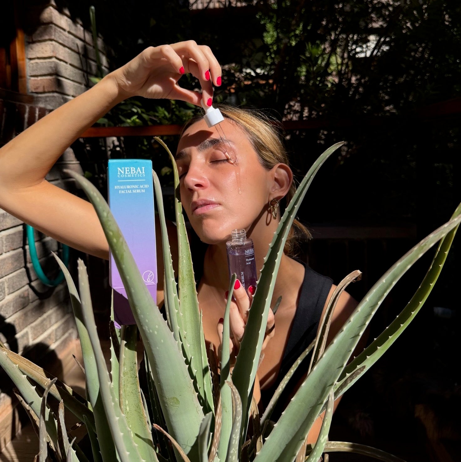 Modelo aplicándose el Serum de Ácido Hialurónico Nebai Cosmetics con el gotero
